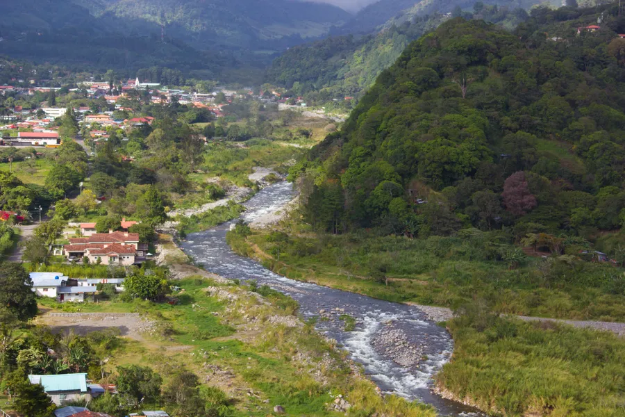 Rocky river running through the green valley town of Boquete with mountains beyond