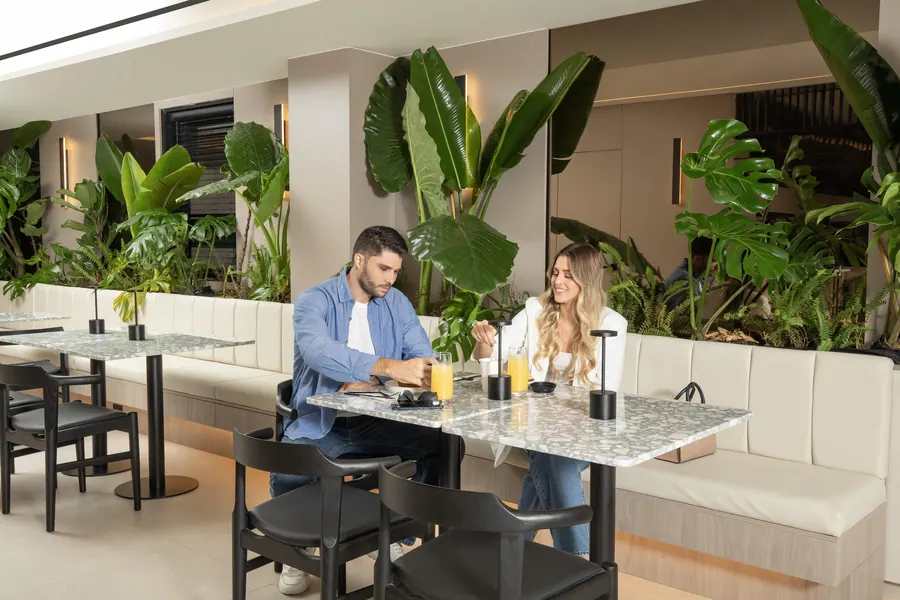 Couple with fresh drinks at a terrazzo table in La Résidence Café.