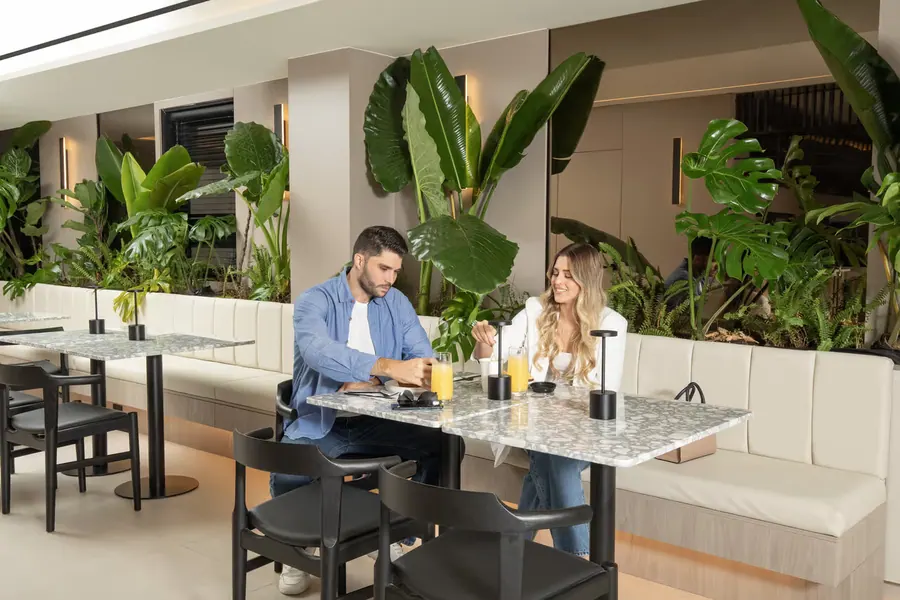 Couple with fresh drinks at a terrazzo table in La Résidence Café.