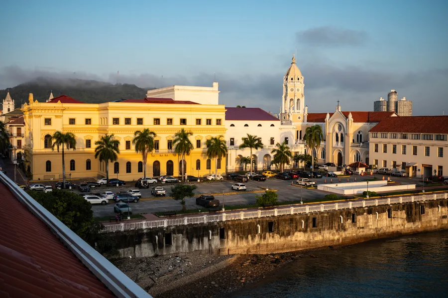 Golden evening light on Casco Viejo's yellow buildings, palms and church tower