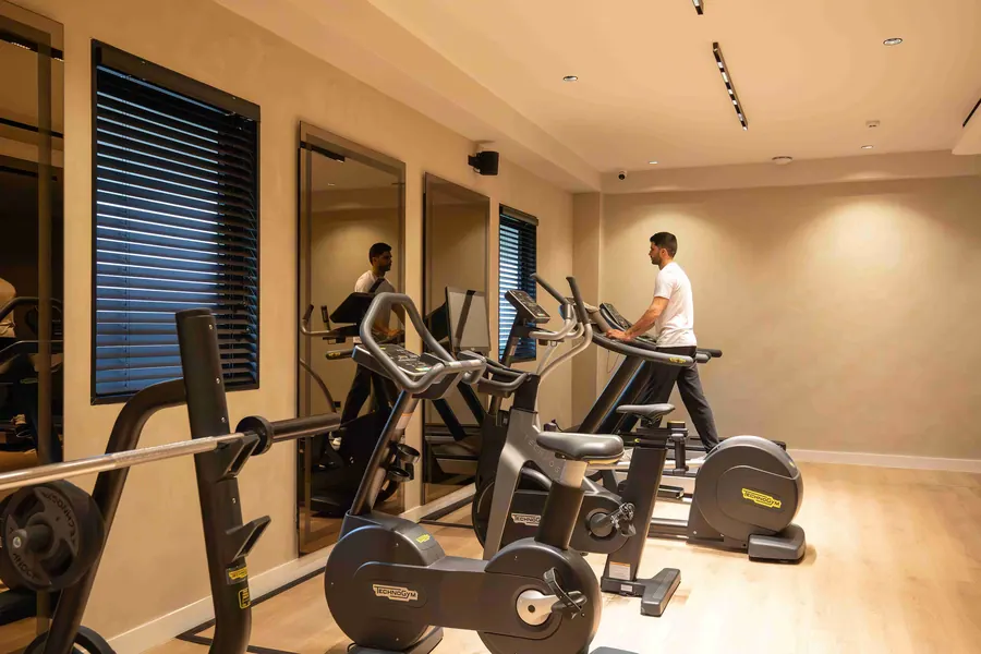 Fitness room with bikes, treadmills and warm wood flooring.