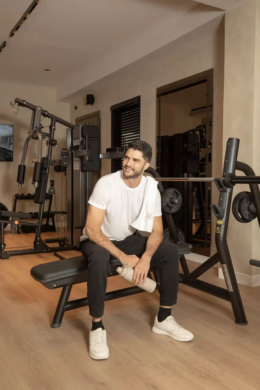 Guest seated on a weight bench in the fitness room.