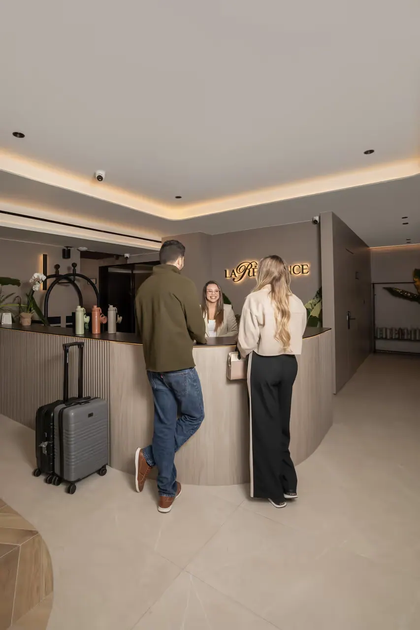 Guests with luggage at the reception counter.