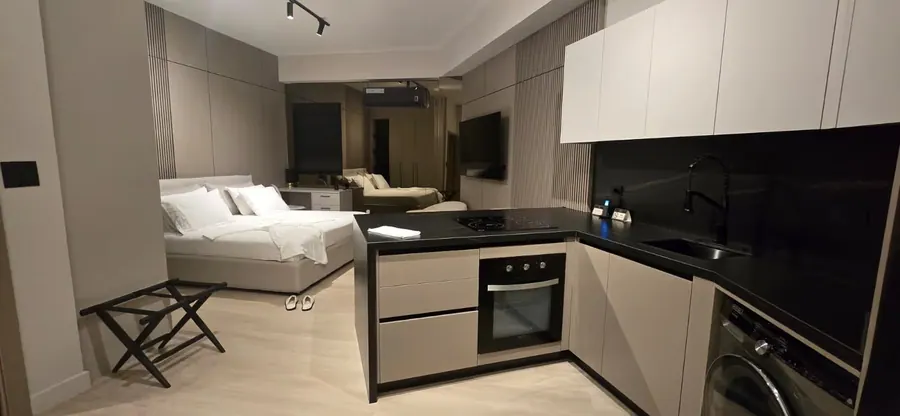 The Corner Suite bed and kitchen with washer and dryer.